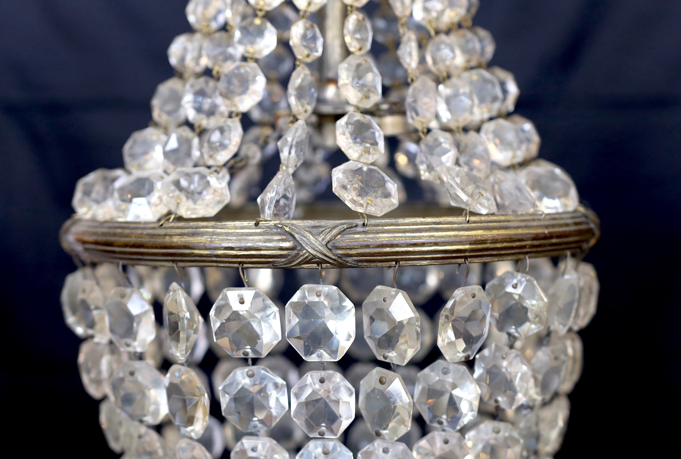 An early 20th century bronze and beaded crystal bag shaped chandelier with graduated octagonal cut drops, height 50cm. width 30 cm